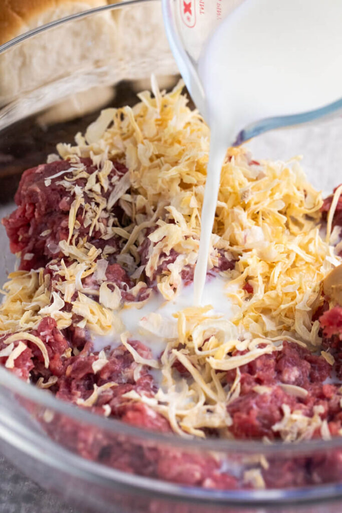 A bowl of ingredients added with milk for White Castle Burger Copycat Recipe.