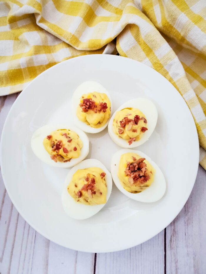 This is simply the best deviled eggs with bacon recipe you will ever try! It is a family favorite, and one of the most requested party side dishes anytime I host or attend.