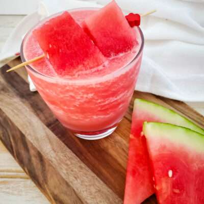 watermelon cocktail with watermelon slices on wood board
