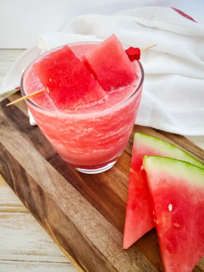 watermelon cocktail with watermelon slices on wood board