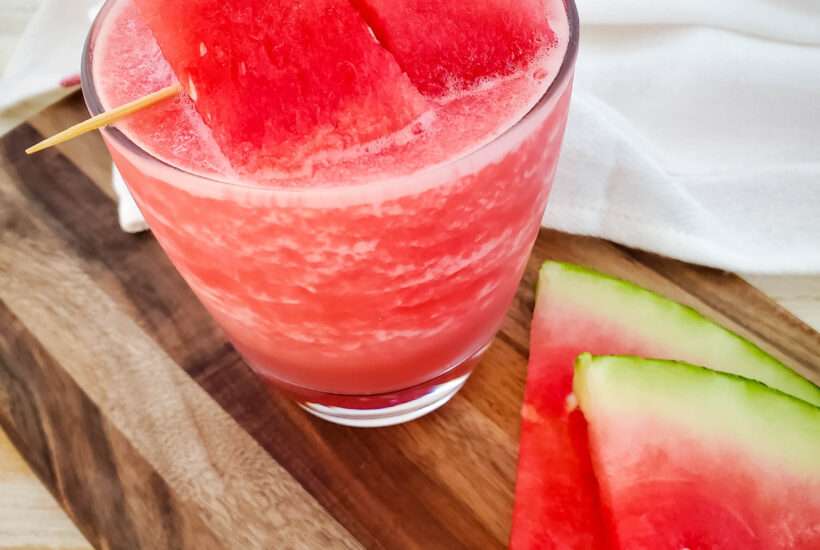 watermelon cocktail with watermelon slices on wood board