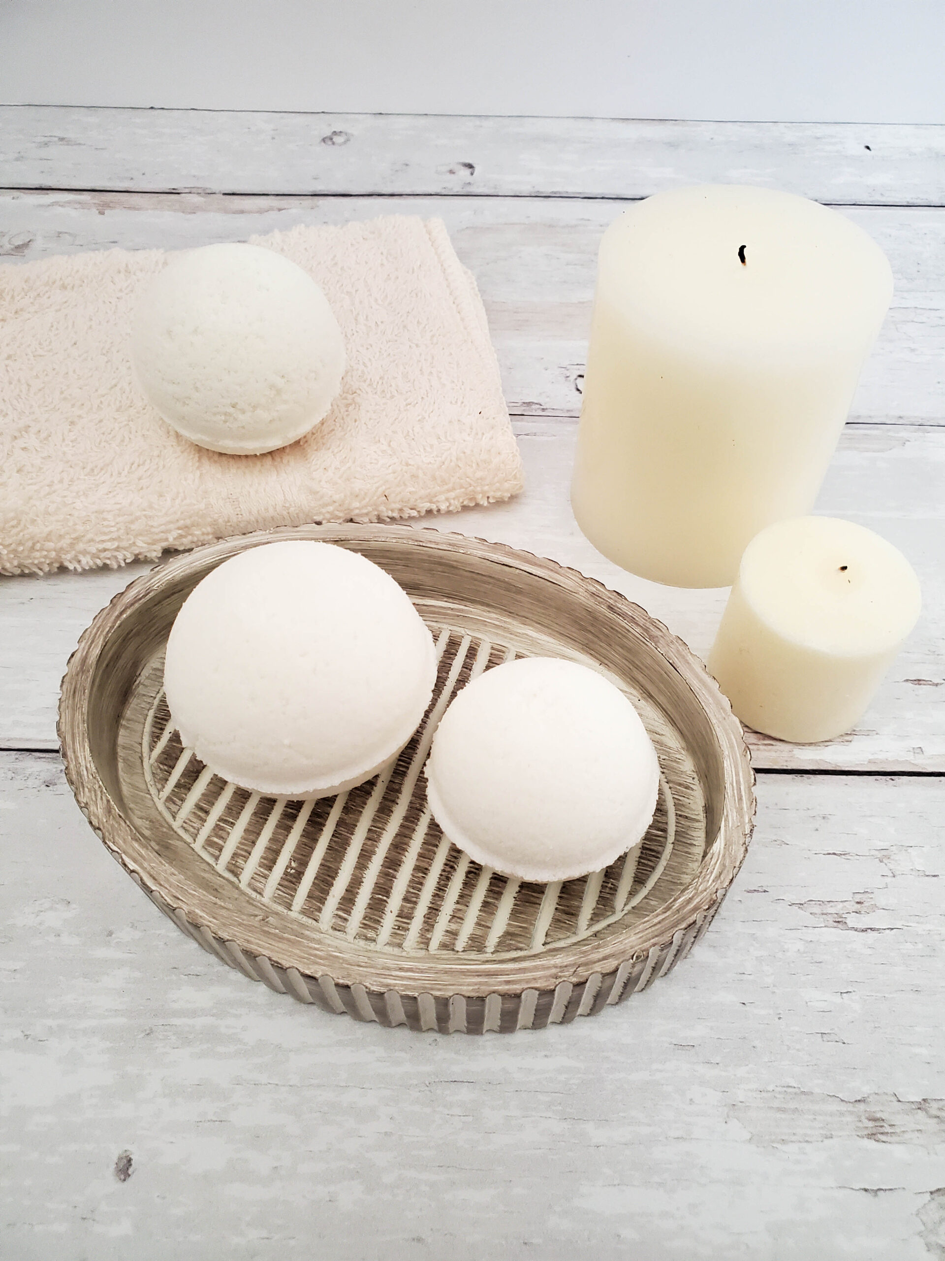 Milk Bath Bombs on a dish, a drying towel with candles