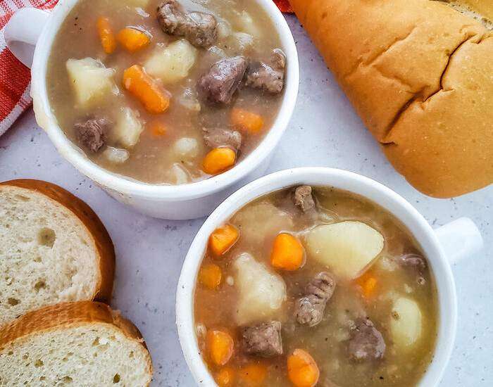 beef stew in white bowls with bread