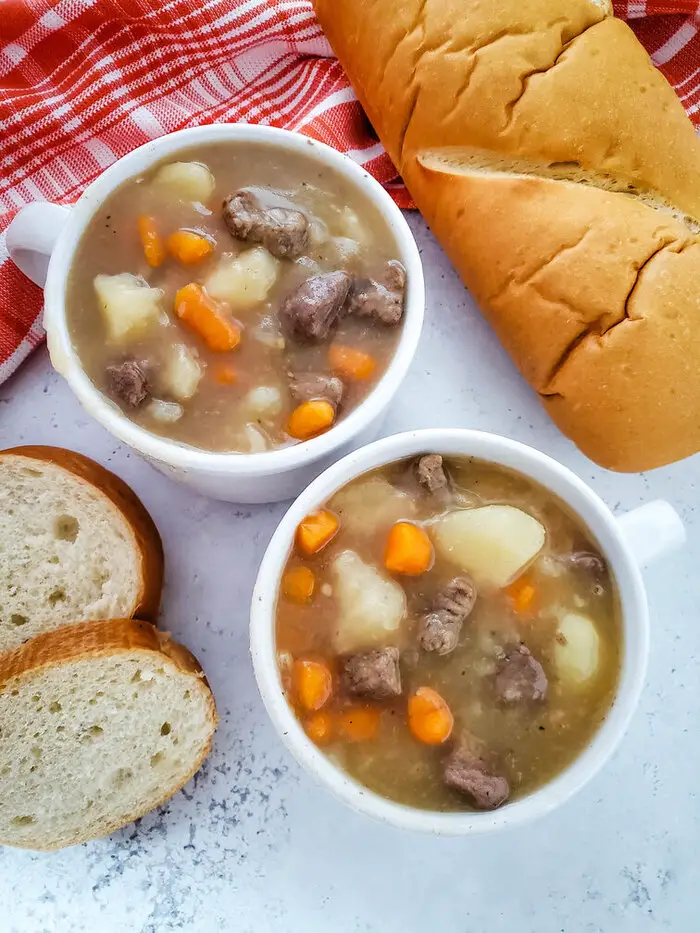 beef stew in white bowls with bread