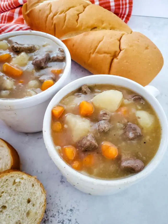 stew with bread in white mug