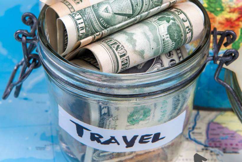 traveling and earning money - money in jar on map