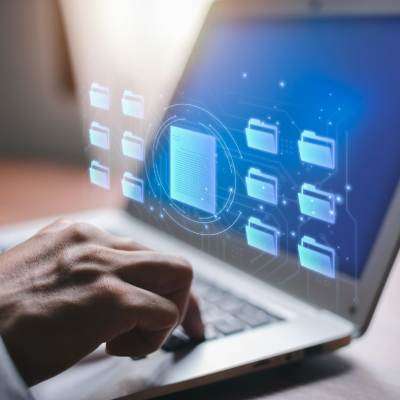 computer with files over it and a man's hand
