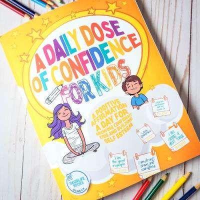 A Daily Dose of Confidence For Kids - A Confidence Boosting Book on white table with colored pencils