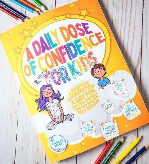 A Daily Dose of Confidence For Kids - A Confidence Boosting Book on white table with colored pencils