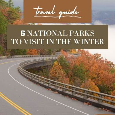 text: travel guide road with fall foliage and a lake