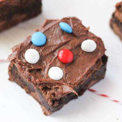 frosted brownie topped with m&ms on white counter