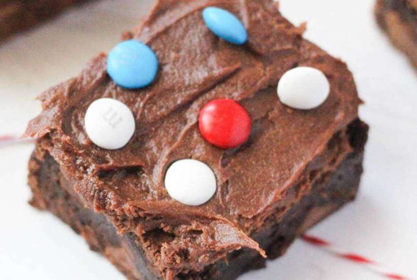frosted brownie topped with m&ms on white counter