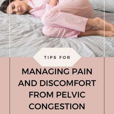 person in pink pajamas lying on bed holding abdomen