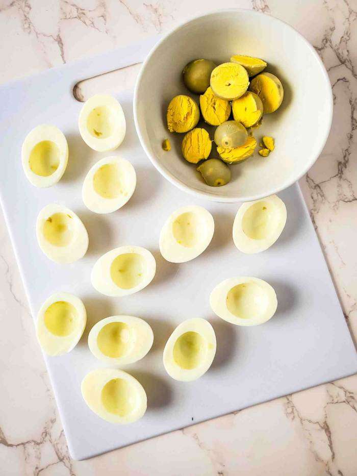 hard boiled eggs cut in half with the yolks in a bowl
