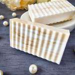goat milk honey soap bar on black counter with pearls