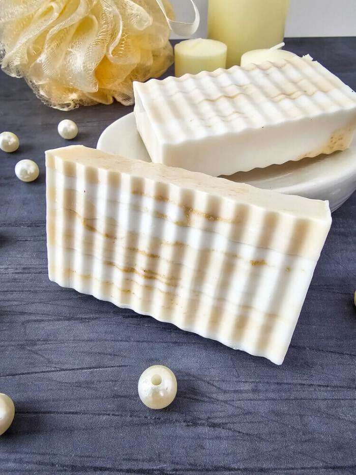 goat milk honey soap bar on black counter with pearls