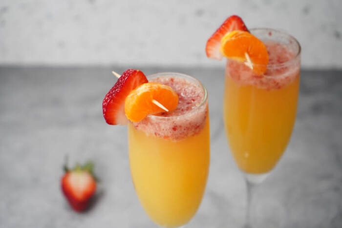 Strawberry Mimosa Recipe in glasses with orange slices and strawberry slices