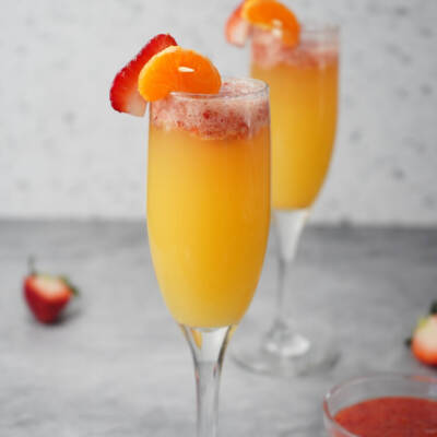 Strawberry Mimosas in glasses with orange slices and strawberry slices