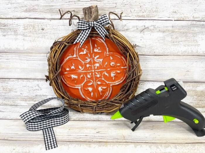 adding finishing touches to Dollar Tree Pumpkin Craft