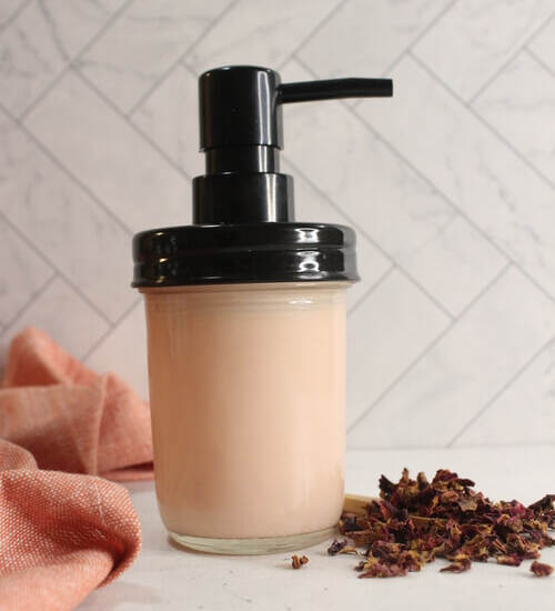 DIY Rose Lotion in a glass bottle with rose petals