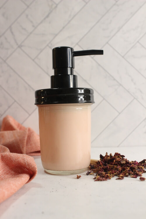 DIY Rose Lotion in a glass bottle with rose petals