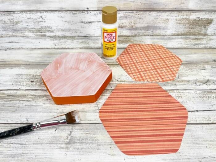 adding modge podge to the wooden pieces