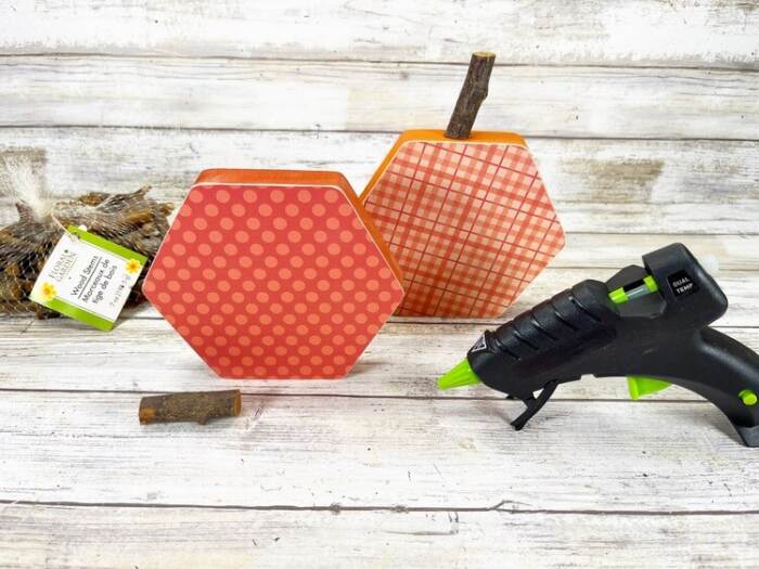 adding the wooden stems to the Hexagon Pumpkin Craft Activity