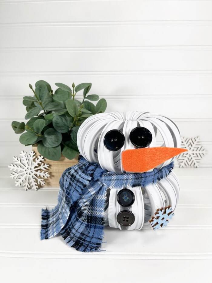 Mason Jar Lid Snowman DIY with a plant in the background