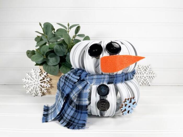 Mason Jar Lid Snowman DIY with a plant in the background