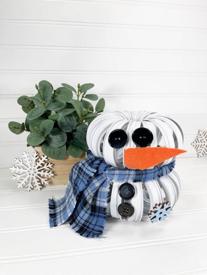 Mason Jar Lid Snowman DIY with a plant in the background