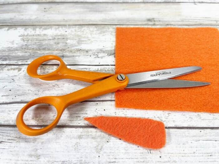 cut the orange felt into a carrot shape nose
