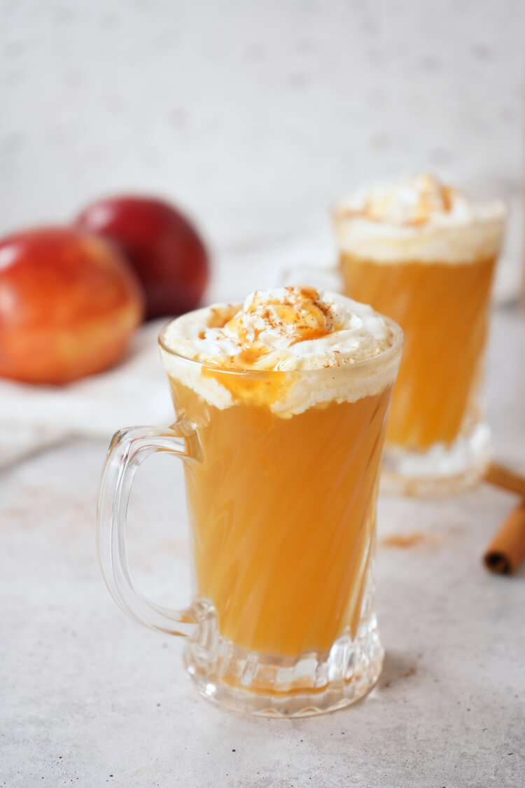 2 glasses of Warm Bourbon Apple Cider with whipped cream on top