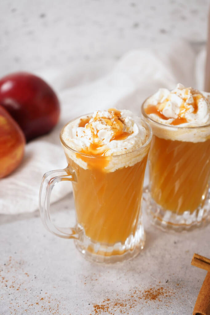 2 glasses of Warm Bourbon Apple Cider with whipped cream on top