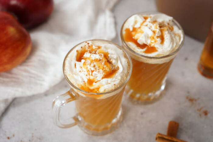 2 glasses of Warm Bourbon Apple Cider with whipped cream on top