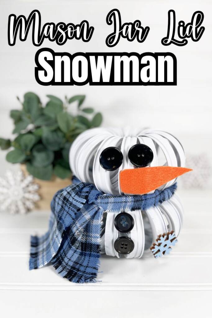 text: mason jar lid snowman
snowman craft on white wood board with plant