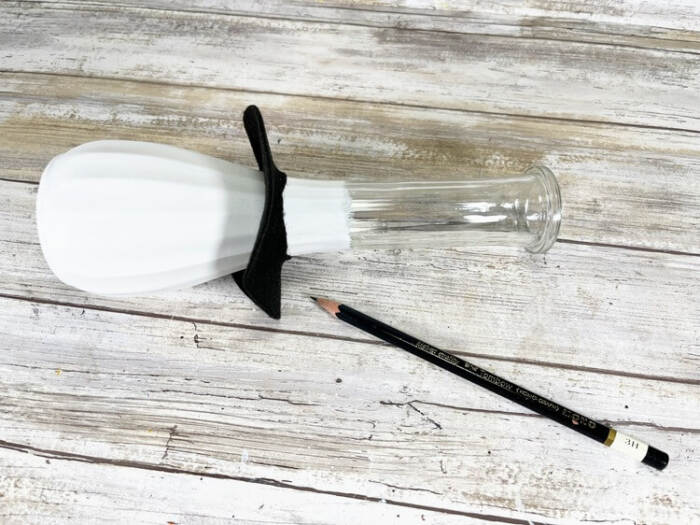 Black felt hat brim fitted around the painted glass vase to mark placement.