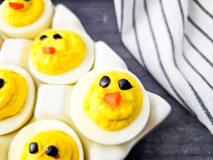 Deviled eggs shaped like baby chicks for Easter appetizers.