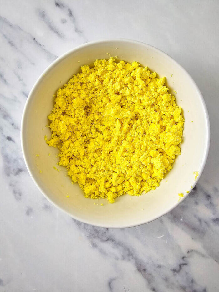 Egg yolks mashed in a bowl for Easter Chick Deviled Eggs filling.