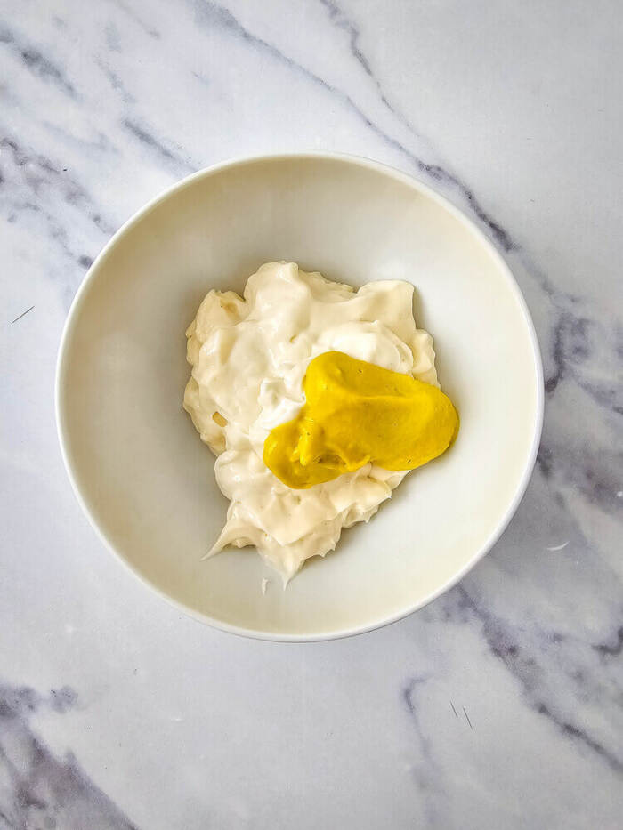 Mayonnaise and mustard added to egg yolks for deviled eggs.