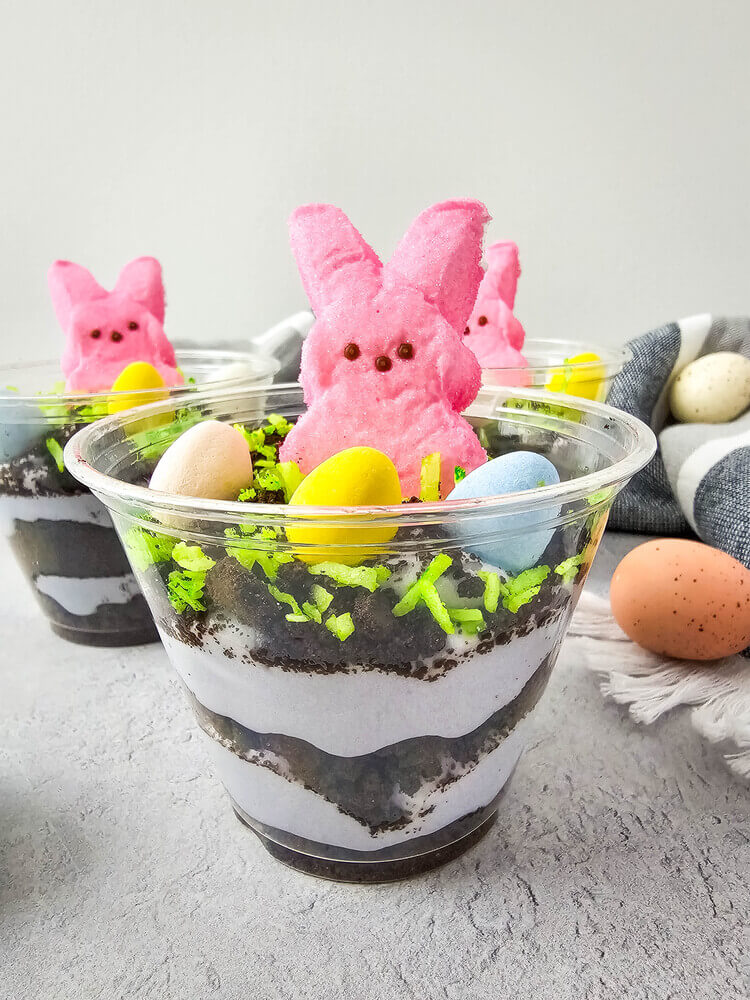 Easter Peeps Dirt Cups in clear cups with Oreo crumbs and green coconut.