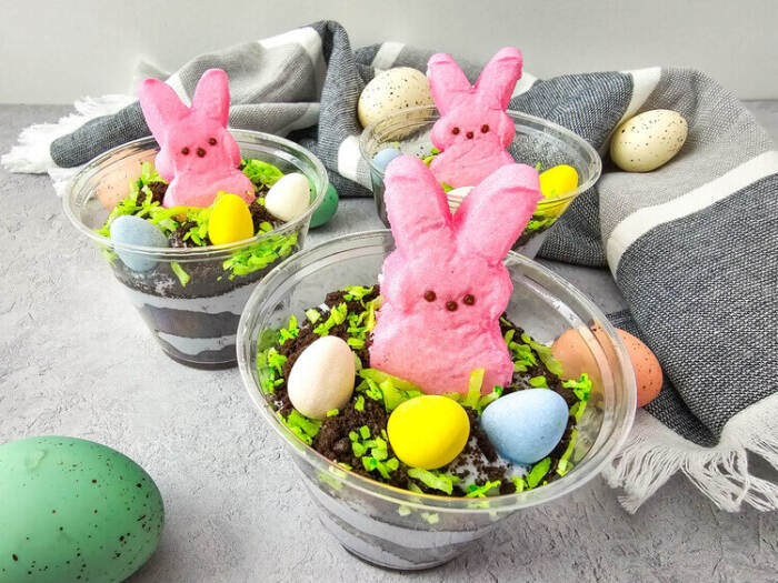 Close-up of Easter Peeps Dirt Cups layered with pudding and cookie crumbs.