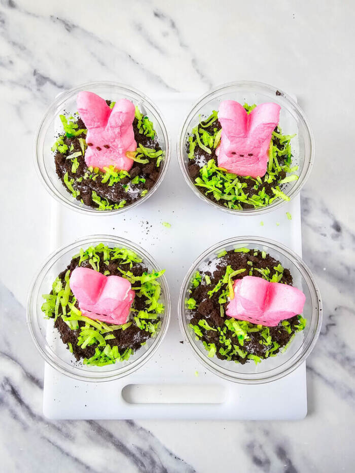 Green coconut sprinkled over dirt cups for Easter Peeps Dirt Cups.