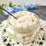 Lemon vanilla whipped sugar scrub in a glass jar with spoon.