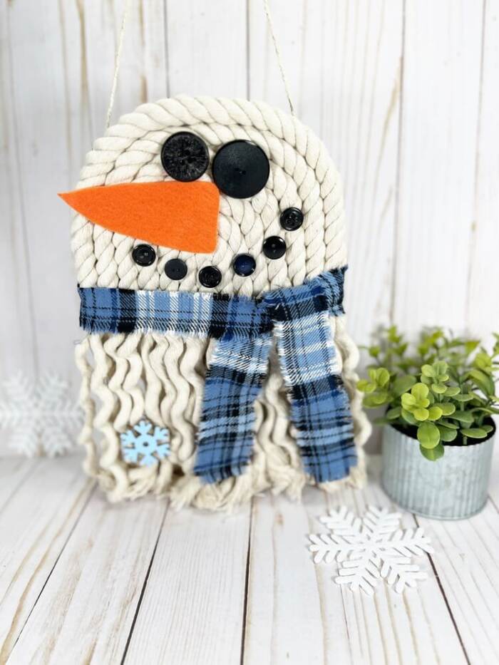 Rope snowman wall hanging with blue plaid scarf and button face.