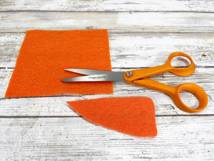 cutting orange felt carrot nose for rope snowman craft