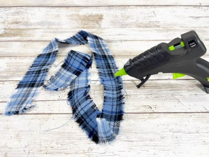 hot gluing fabric scarf pieces for diy rope snowman