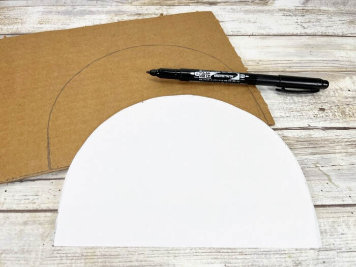 Tracing snowman shape on cardboard for rope craft.