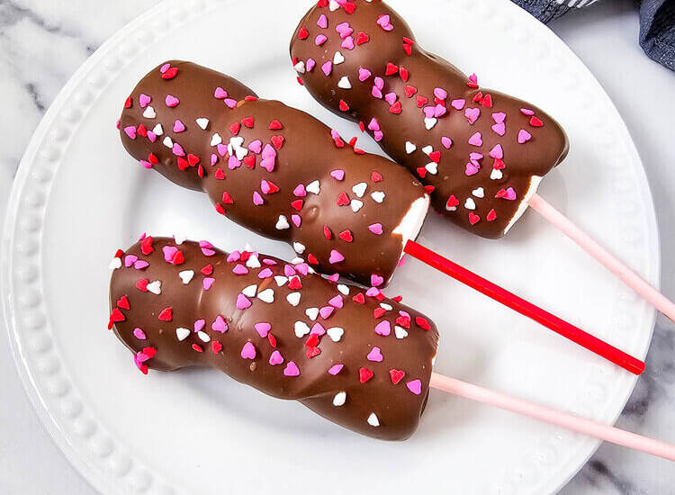 Valentine’s-themed marshmallow pops with pink and red candy and sprinkles on sticks