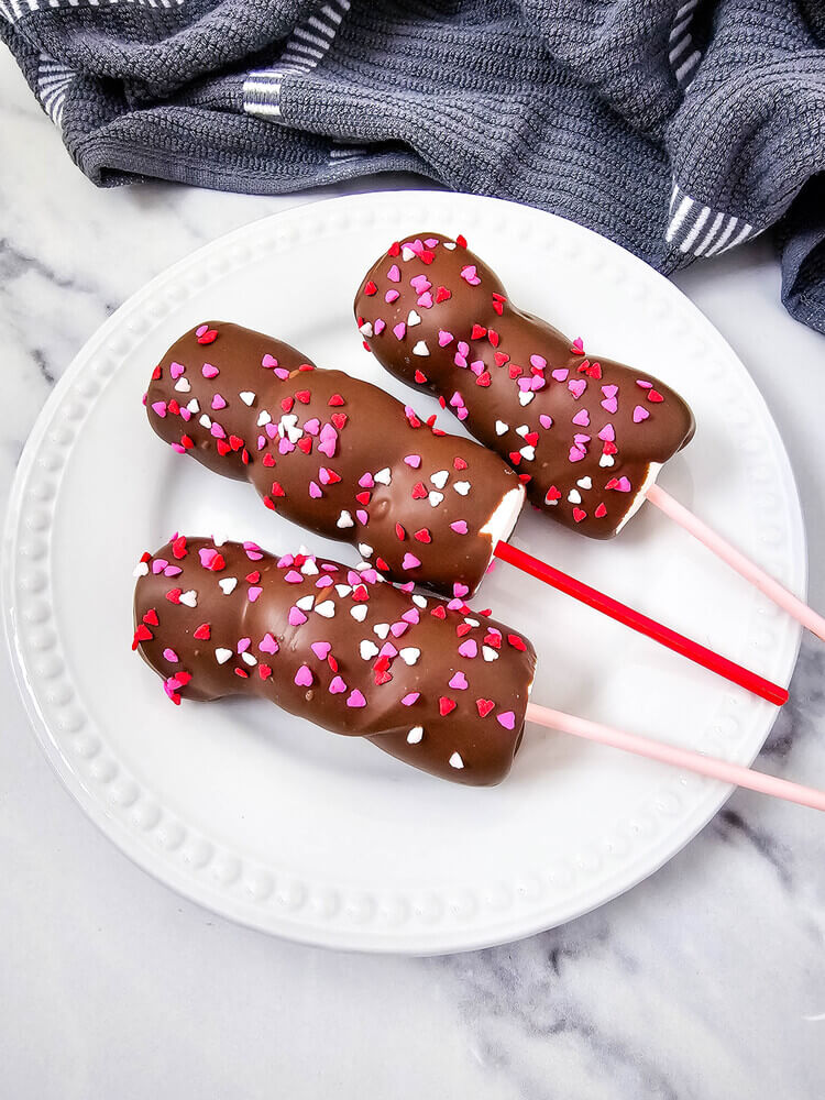 Valentine’s-themed marshmallow pops with pink and red candy and sprinkles on sticks