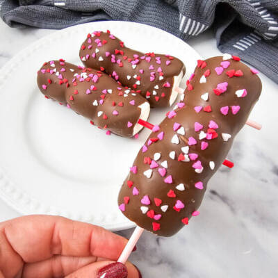 Valentine’s-themed marshmallow pops with pink and red candy and sprinkles on sticks